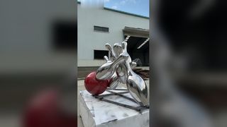 Зеркальная скульптура боулинга из нержавеющей стали ярко передает динамичный момент.